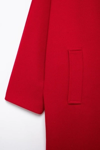 Detailed close-up of red wool coat sleeve and pocket showing fabric texture and stitching