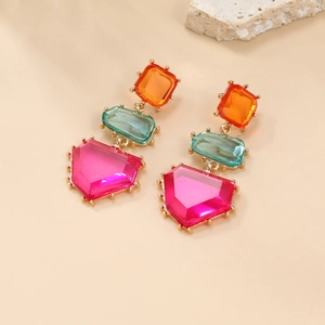 Detail of colorful geometric drop earrings with orange, teal, and pink faceted gemstones