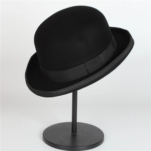 Close-up of a classic black wool felt bowler hat with a ribbed ribbon on a display stand