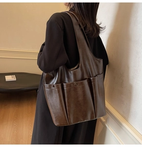 Detail of soft PU leather shoulder bag with three front pockets and oil wax finish