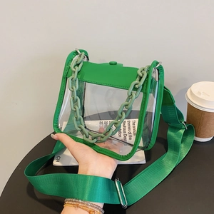 Close-up of transparent green PVC crossbody bag featuring bold chain and nylon strap