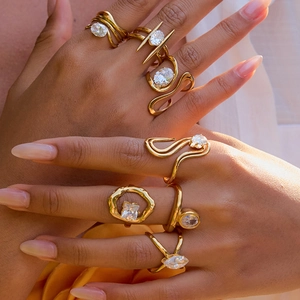 Elegant gold zircon rings with geometric designs and sparkling white stones on a hand