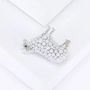Dettaglio di una spilla a pecora con perle bianche e scintillanti strass decorativi