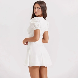 Detail view of white French puff sleeve mini dress showing back silhouette and fabric texture