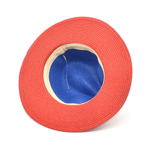 Detail of red and blue color-block straw hat with woven texture and comfort sweatband