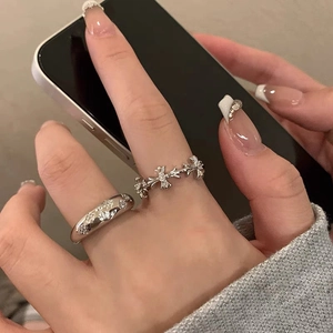 Set di anelli a croce in argento con pietre scintillanti sulla mano di una modella