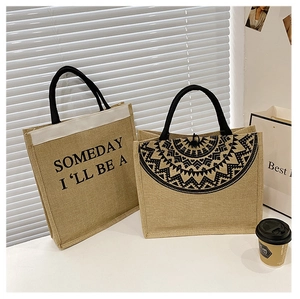 Detailed view of two khaki jute tote bags with geometric patterns and English text