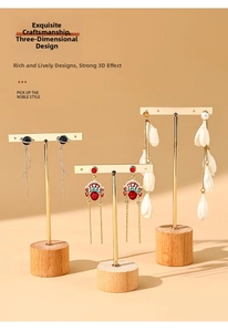 Three-piece earring set displayed on golden T-bar stands with wooden bases for jewelry