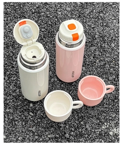 Detail view of pink and white stainless steel vacuum flasks with orange press buttons