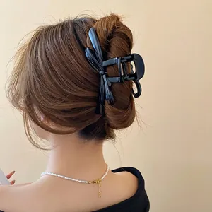 Elegant black bow hair claw clip for women, versatile 3D design shown on model's hair