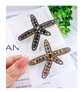Close-up of alloy starfish hair clips with sparkling rhinestones in grey and amber
