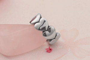 Macro shot of silver heart-shaped vintage rings interlocking on pink crystal