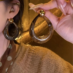 Smoky grey resin teardrop hoop earrings with gold metal studs shown on model