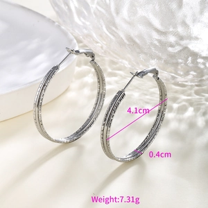 Macro shot of silver hoop earrings showing 4.1cm diameter and grid texture detail