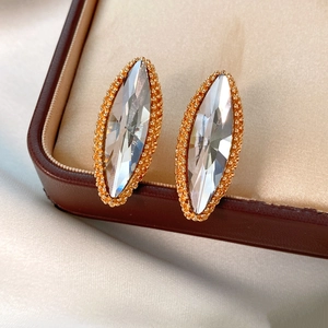 Close-up of vintage gold beaded earrings with marquise crystal on a jewelry box display