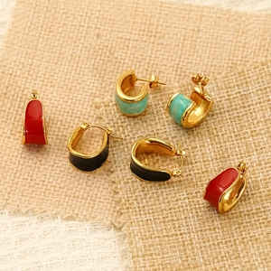 Three pairs of C-shaped enamel gold hoop earrings in red, black and turquoise colors