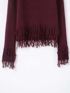 Detailed macro view of the wine red knit cardigan featuring long fringe tassels on the hem