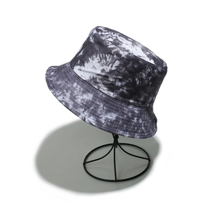 Detail view of tie-dye bucket hat with marble texture displayed on a metal stand