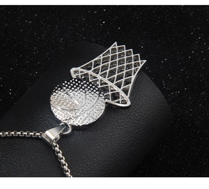Detailed view of silver stainless steel basketball and hoop pendant on a black background