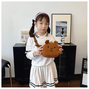 Detailed view of kids plush bear crossbody bag with adjustable strap on a small model