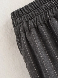 Détail de la taille élastique et des poches latérales sur pantalon gris à rayures