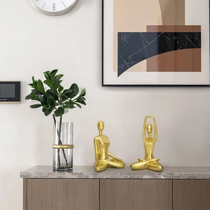 Modern gold yoga figure statues for home decor in a minimalist living room setting