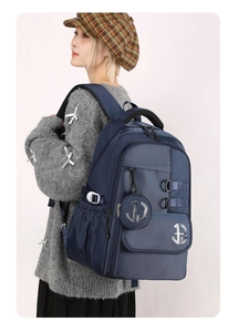 Side view of dark blue nylon backpack with round pouch shown on a male model