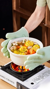 Detail of mint green heat-resistant silicone glove showing non-slip texture and flexible grip