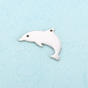 Polished stainless steel hollow dolphin pendant on a textured light blue background