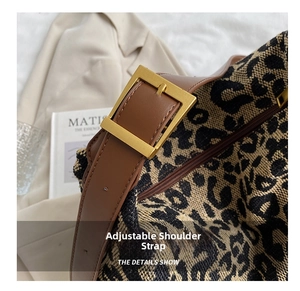 Close-up of adjustable brown leather shoulder strap and gold buckle on leopard print bag