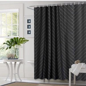 Modern black and white chevron geometric shower curtain in a minimalist bathroom setting