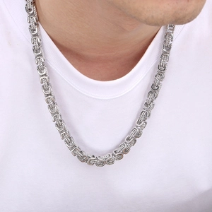 Macro shot of silver Byzantine chain necklace texture on white t-shirt for men