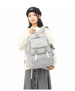 Detailed view of gray backpack with cartoon bear patterns and sturdy buckle closures