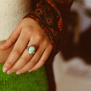 Détail d'une bague vintage en argent avec une opale en goutte aux reflets colorés