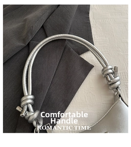 Close-up of silver metallic handbag featuring unique double knotted rope handle detail