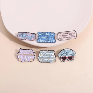 Set of 6 pastel enamel pins with inspirational lyrics on a minimalist white tray