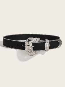 Detail of a vintage black leather belt with silver studs and an ornate carved metal buckle