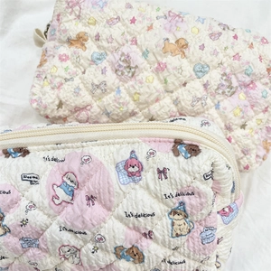 Close-up of quilted cotton pouches featuring cute puppy prints and metal zipper details