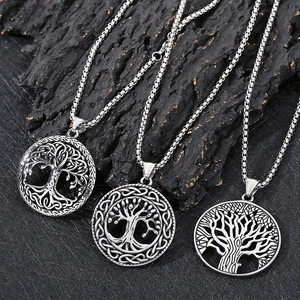 Three Viking Tree of Life round pendants on textured black stone background