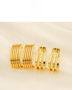 Detail of 18K gold plated multi-layer earrings on white silk ribbon background