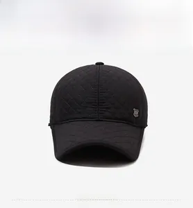 Détail de la casquette matelassée noire avec motif losanges et badge métallique
