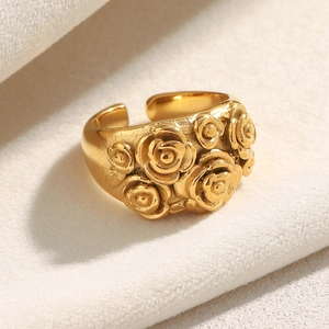 Detailed view of 18K gold plated wide band ring featuring embossed rose flower patterns