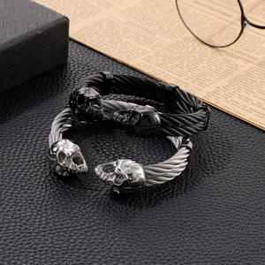 Detail of punk double skull wire cable bracelets in black and silver steel