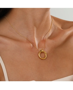 Nahaufnahme der goldenen Halskette mit drei ineinandergreifenden Ringen am Hals