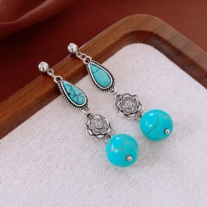 Detailed view of bohemian turquoise drop earrings with vintage flower design