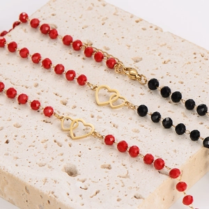 Handmade minimalist gold chain bracelets with red and black beads featuring double heart charms
