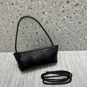 Detail of woven black leather texture and gold zipper on a chic crossbody bag