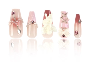 Detailed close-up of pink press-on nails with white angel relief and pearl bow accents