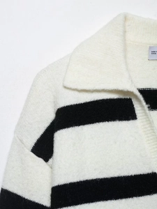 Detailed close-up of cream and black striped knit sweater with large lapel and texture