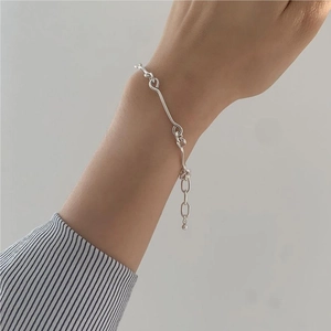 Detail of minimalist S925 sterling silver knotted bracelet on female wrist